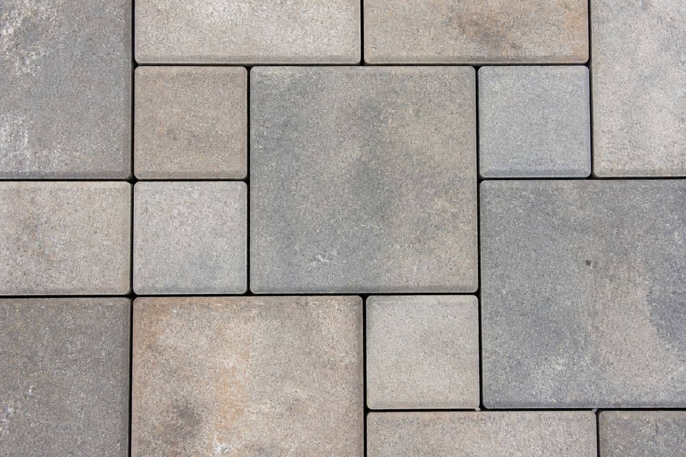Paver walkway leading to a landscaped patio