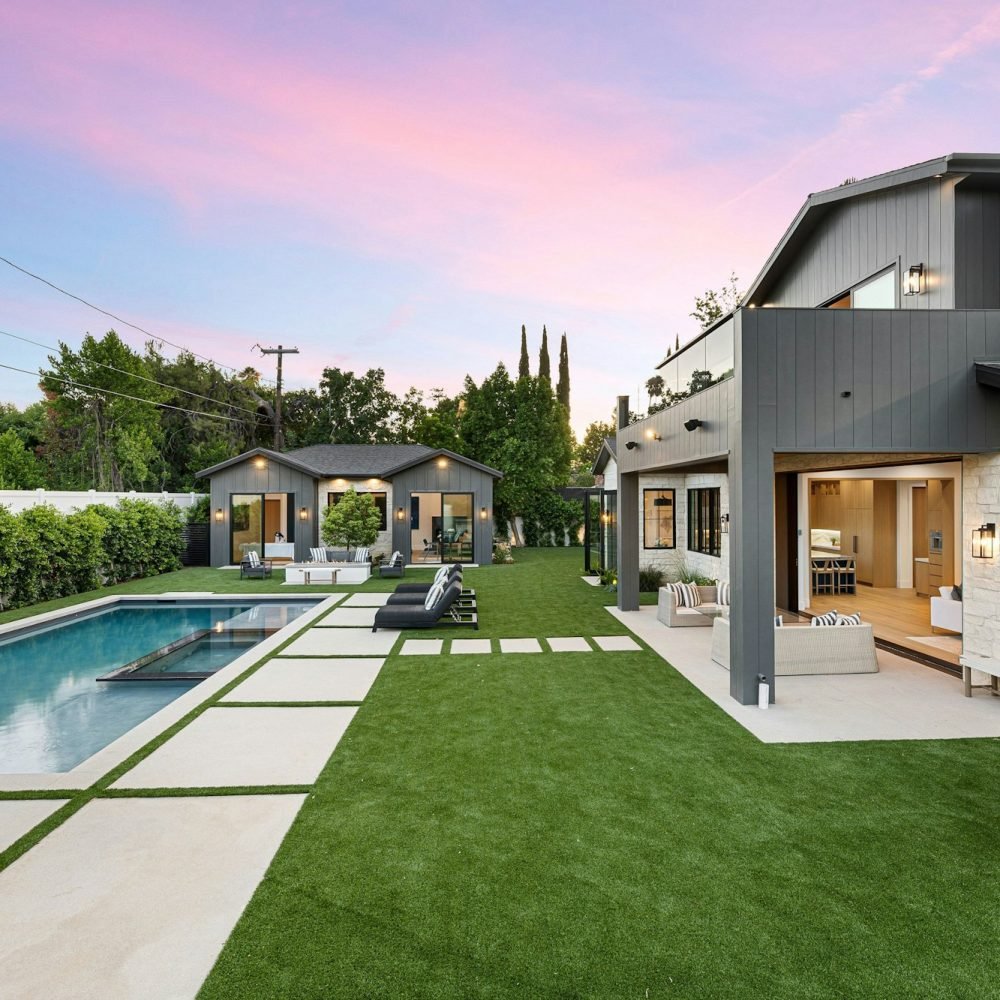 Modern backyard with pool and patio at sunset